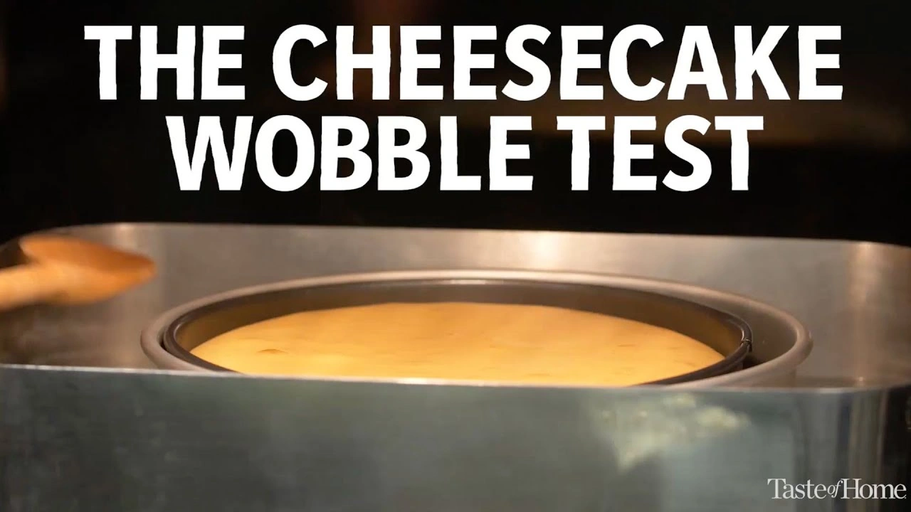 Jak Zrobić Sernik Idealny? Sprawdzone Triki, Które Działają Za Każdym Razem A cheesecake in a springform pan inside a water bath for the wobble test to check if it's done baking.