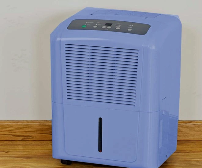 Jak Pozbyć Się Wilgoci z Domu: Szybkie i Skuteczne Rozwiązania Blue portable dehumidifier on wooden floor designed to reduce moisture and prevent mold growth indoors.
