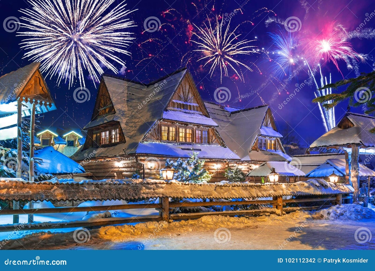 Gdzie na Sylwestra w Polsce? Wyjątkowe Miejsca na Powitanie 2026 Roku Colorful New Year's fireworks light up the night sky over snow-covered traditional wooden houses in Zakopane, Poland.