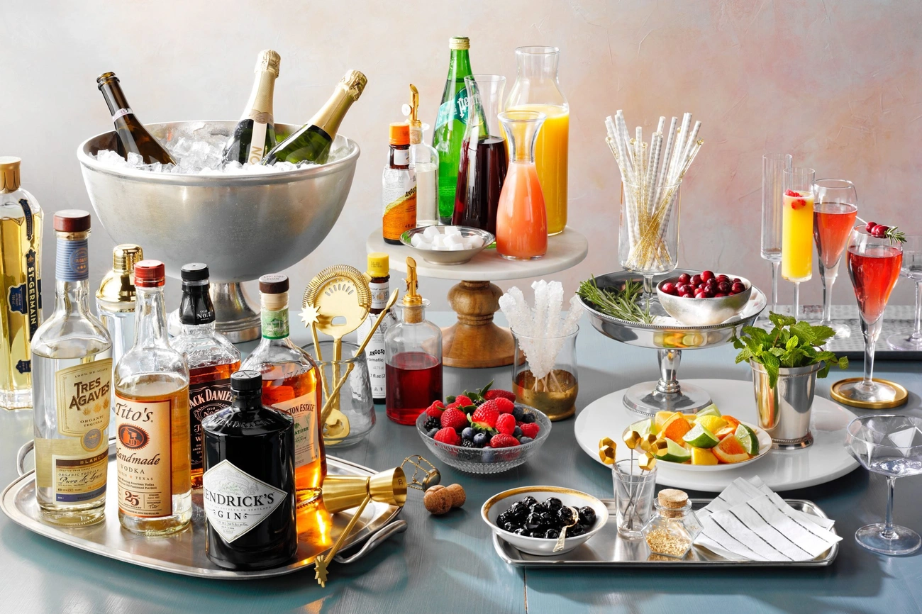 A festive champagne bar setup with bottles, mixers, fresh fruit, garnishes, and sparkling wine glasses ready for celebration.